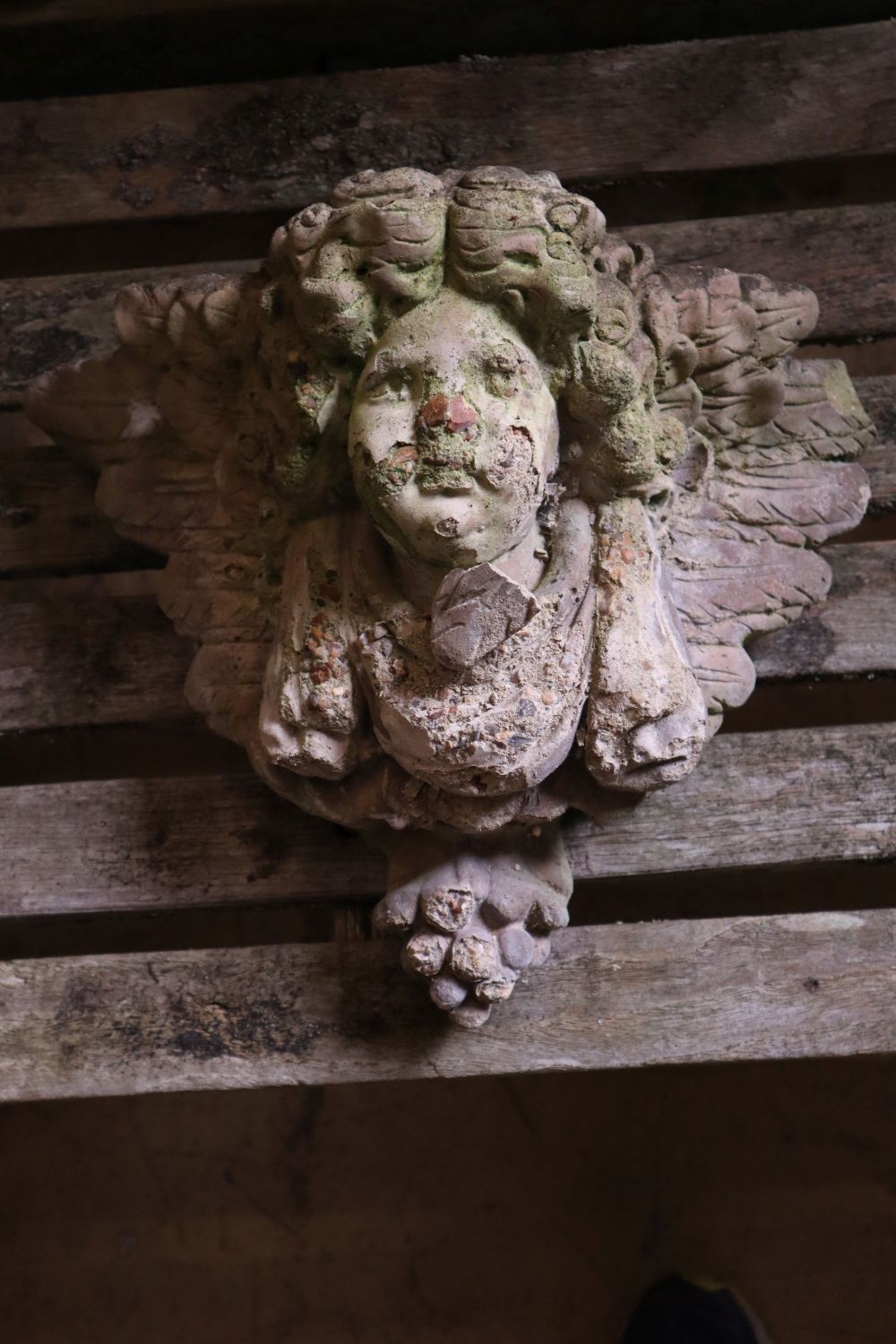 Three reconstituted stone cherub garden wall appliques, tallest 32cm